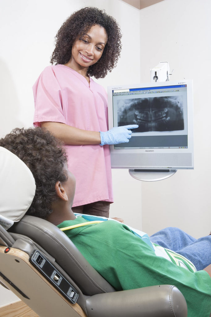 technician-showing-dental-x-ray-to-patient-stockunlimited-2081659
